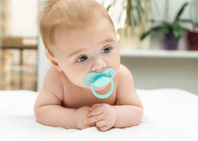 Close-up Portrait Of A Little Baby Boy With Pacifier On Mouth. C